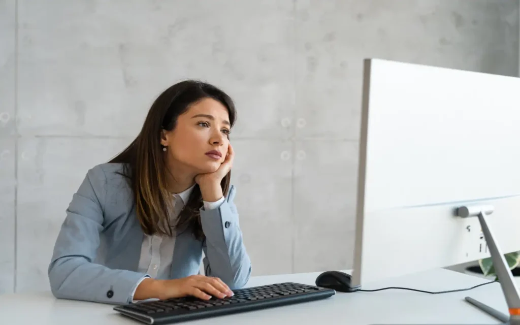 A bored business owner staring at a computer screen waiting for their phone to ring