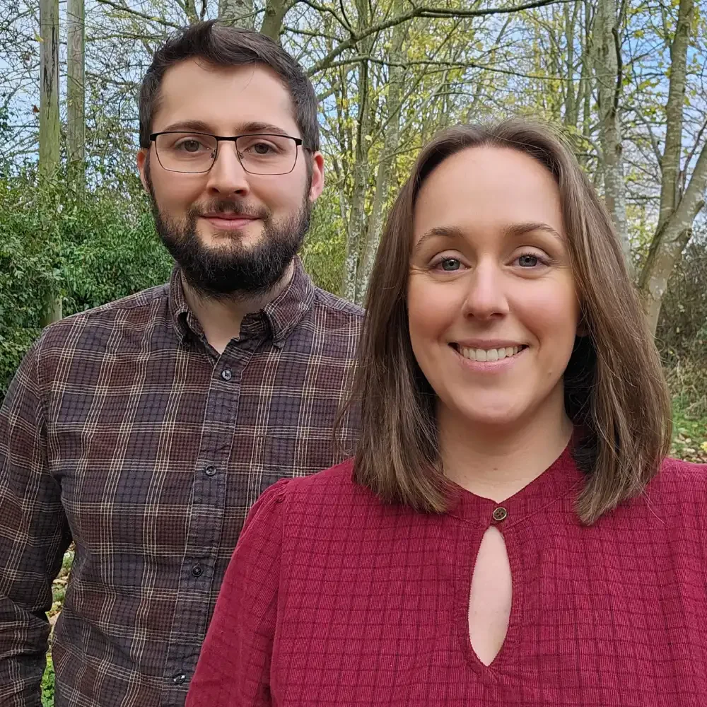 Scott and Laura, Revive Online founders, smiling in an autumnal outdoors scene